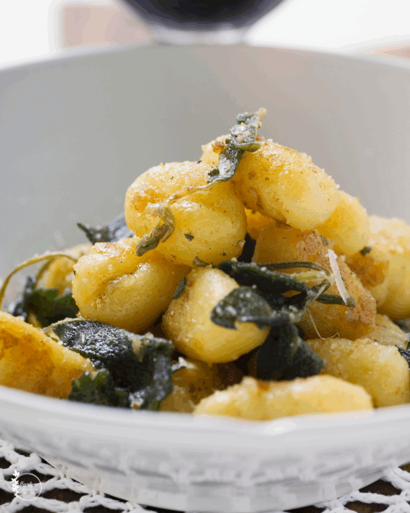 Tányéron tálalt vajas zsályás gnocchi ropogós zsályalevelekkel.
