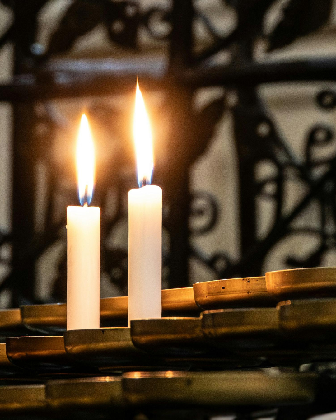 Két fehér gyertya lángja a halottak napi emlékezés és kegyelet jelképeként
