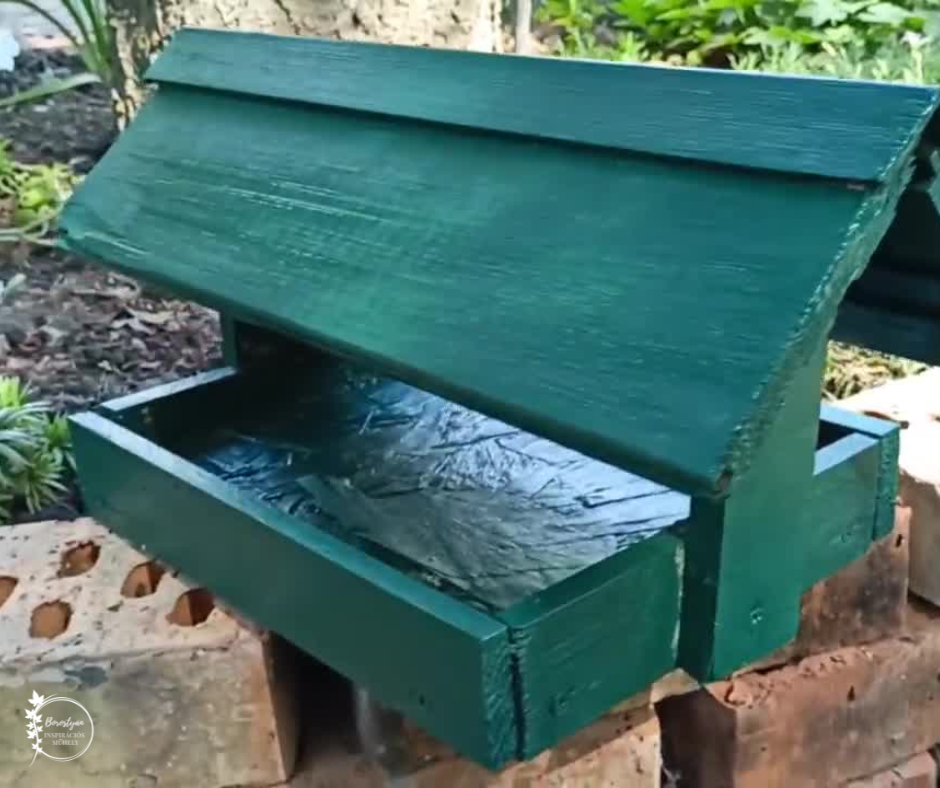 Zöldre festett, fából készült saját madáretetőnk a kertben elhelyezve