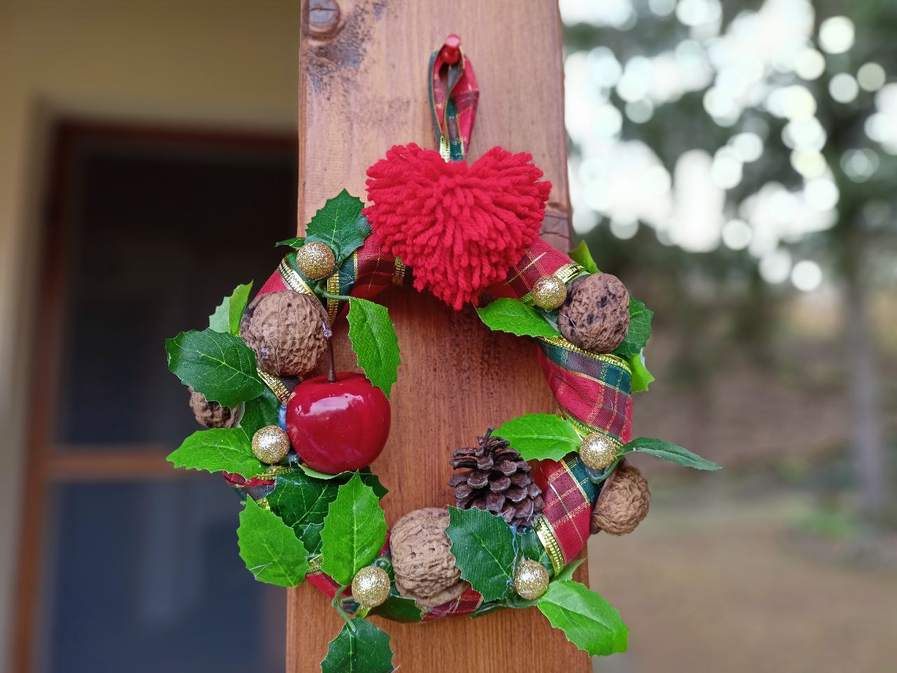 Karácsonyi koszorú hungarocell alapra, dióval, tobozzal, piros szívvel és arany díszekkel.