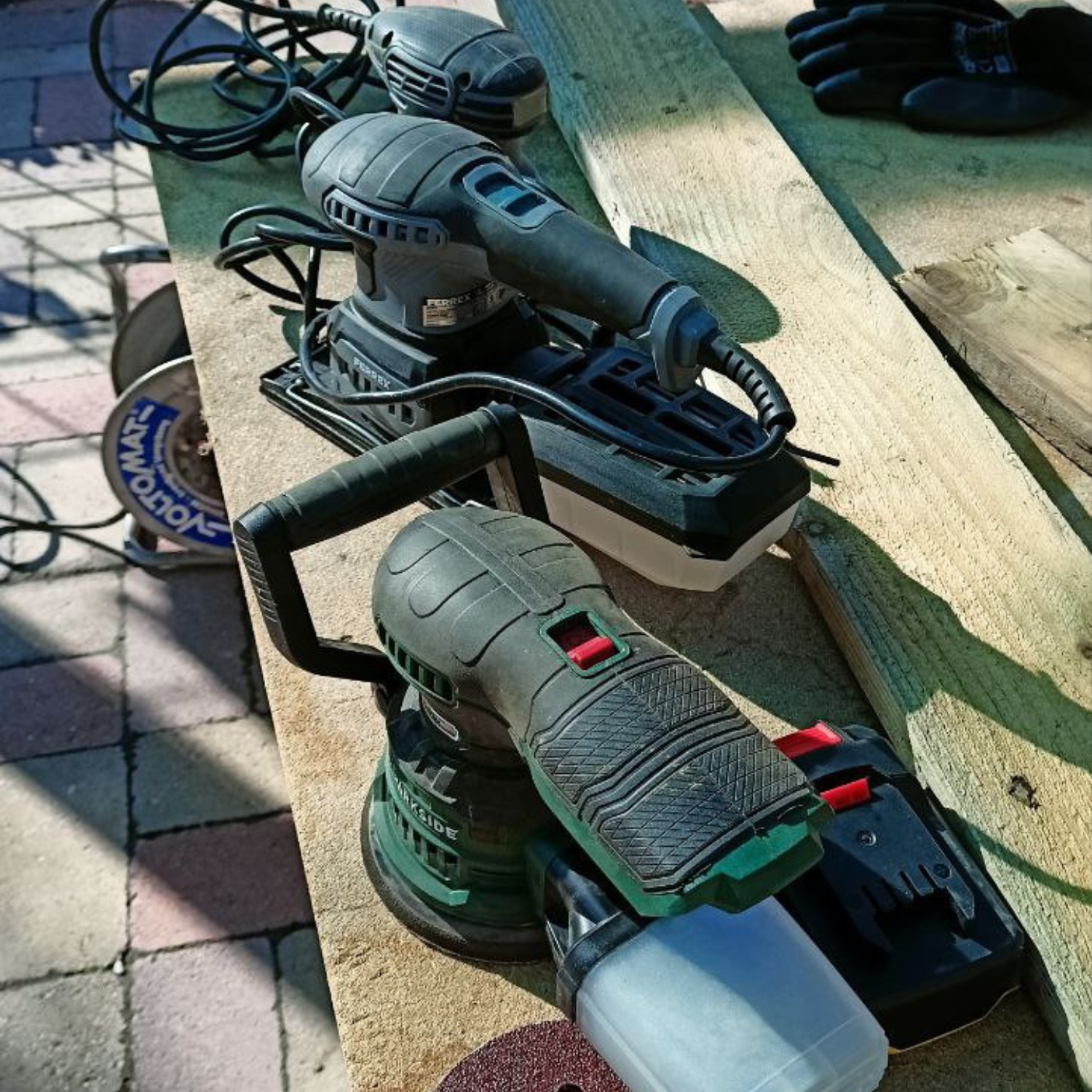 Három különböző csiszológép fa csiszolásához: excenteres, rezgő és delta csiszoló egy munkafelületen