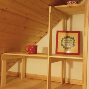 Szellős tetőtéri polc kis helyen, ferde fal alatt kialakítva