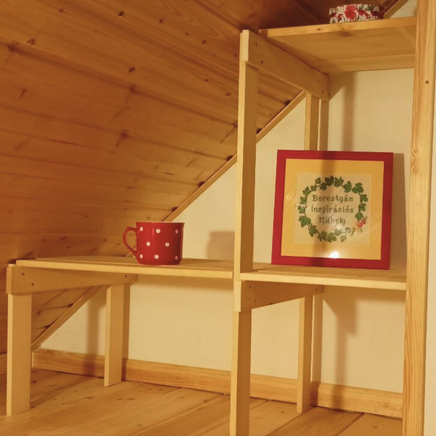 Szellős tetőtéri polc kis helyen, ferde fal alatt kialakítva