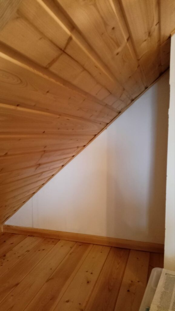 Üres tetőtéri sarok ferde fallal, polc kialakítása előtt